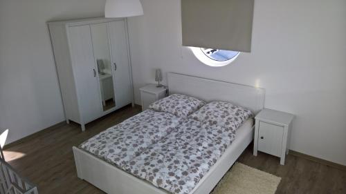 a white bedroom with a bed and a window at AS-Ferienwohnung in Korbach