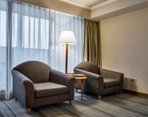 two chairs and a lamp in a hotel room at The Carlton Hotel Hsinchu in Hsinchu City