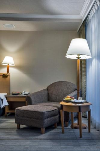 a living room with a couch and a table with a lamp at The Carlton Hotel Hsinchu in Hsinchu City