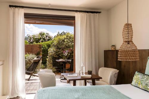 a bedroom with a bed and a table and chairs at Domaine Santa Giulia Palace in Porto-Vecchio