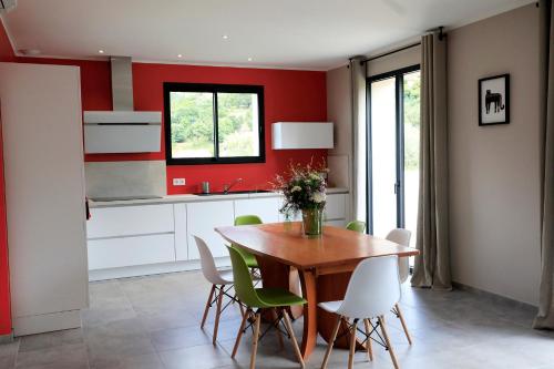 A Casa Leccia في Poggio-dʼOletta: مطبخ مع طاولة خشبية وكراسي خضراء