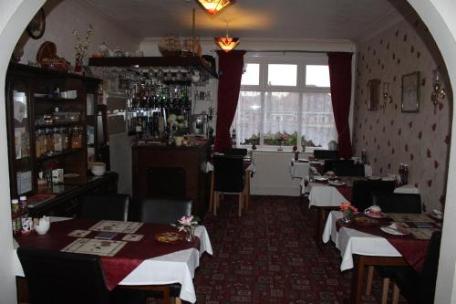 a restaurant with tables and chairs and a window at The Lyndsay Guest House in Skegness