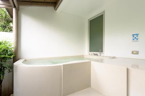 a white bathroom with a sink and a mirror at Costa Village Bangsaray in Bang Sare