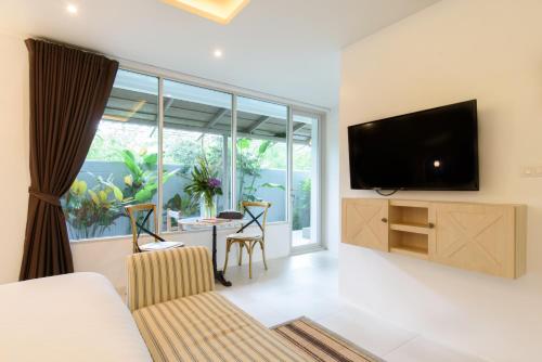 a living room with a flat screen tv on a wall at Costa Village Bangsaray in Bang Sare