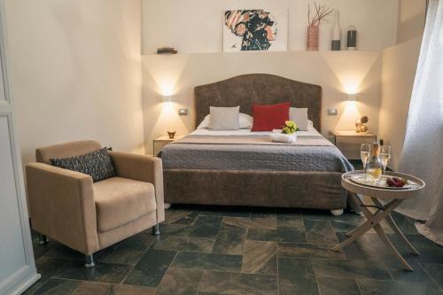 a bedroom with a bed and a chair and a table at Villa La Lumia B&B Suites & Apartments in Agrigento