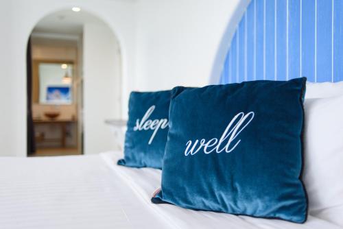 a blue pillow with the words sleep well sits on a bed at Costa Village Bangsaray in Bang Sare