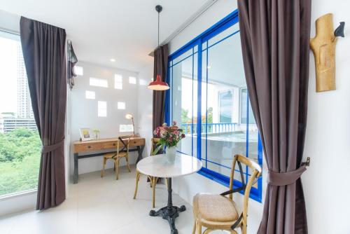 a room with a table and a desk and a window at Costa Village Bangsaray in Bang Sare