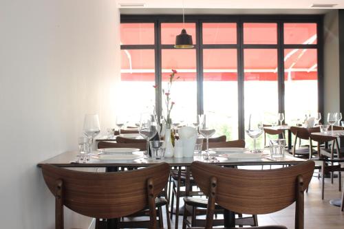 a dining room with tables and chairs and windows at Domus Hotel & Apartments in Shëngjin