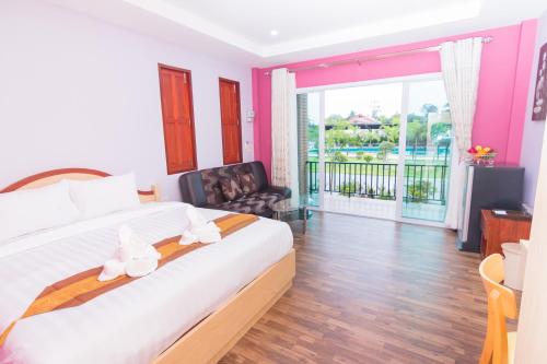 a bedroom with a large bed and a balcony at Samrong Garden in Udon Thani