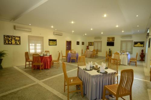 a dining room with tables and chairs and tablesearcher at KMA Bagan Village Hotel in Bagan