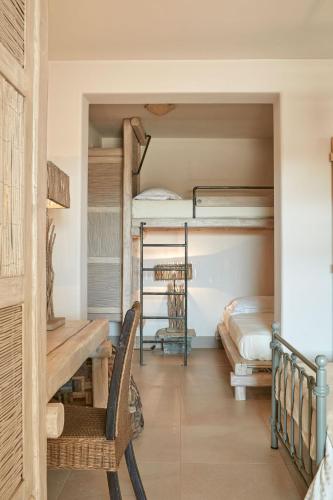 a room with two bunk beds and a table and a chair at Diles & Rinies in Tinos Town