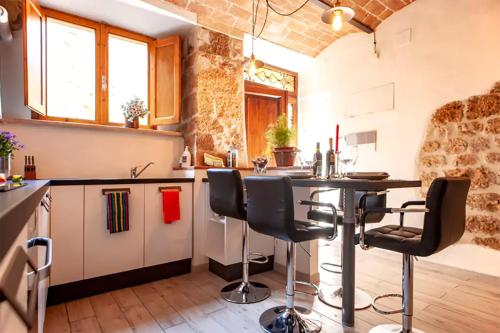 a kitchen with a table and chairs in a room at Casa Volterra in Volterra