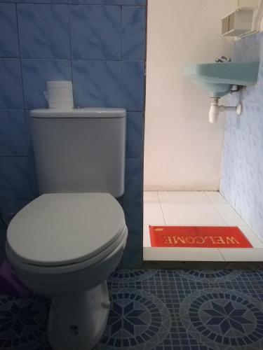 a bathroom with a toilet and a sink at Bintang Bungalow Tour & Travel in Kelimutu