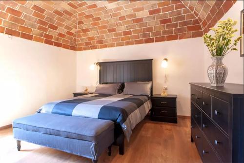 a bedroom with a bed and a brick wall at Casa Volterra in Volterra