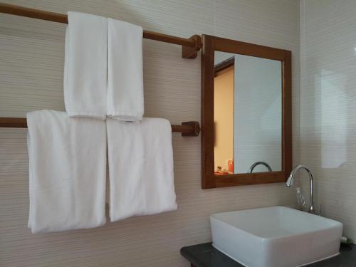 a bathroom with a sink and a mirror and towels at Northern Breeze Hotel in Bagan