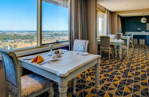 a dining room with a table and a large window at Rainbow Towers Hotel & Conference Centre in Harare