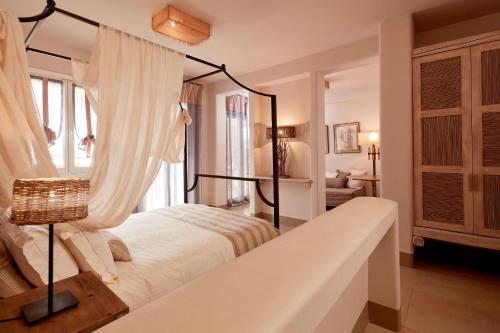a bedroom with a canopy bed in a room at Diles & Rinies in Tinos Town