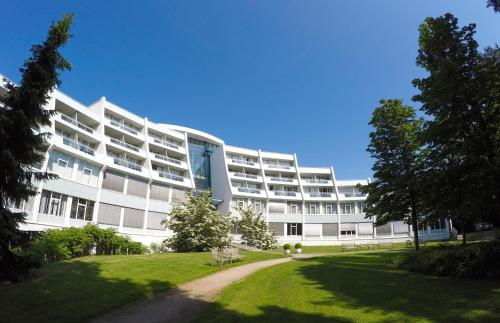 a large white building with a park in front of it at Sanadome Hotel & Spa Nijmegen in Nijmegen