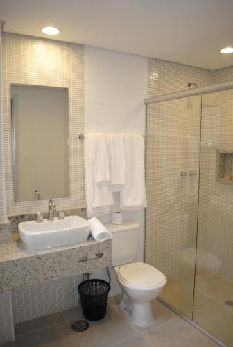 a bathroom with a toilet and a sink and a shower at Hotel Lugus in Sao Paulo