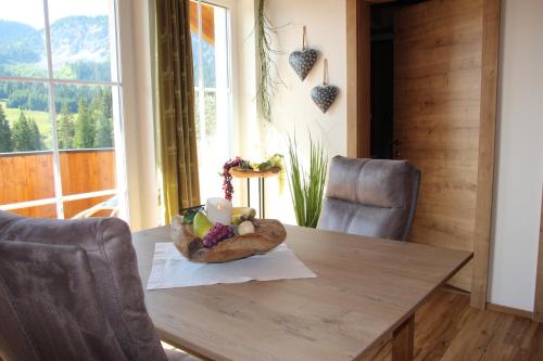a wooden table with a bowl of fruit on it at Am Schwand in Grän