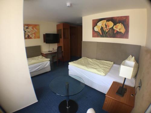 アッシャースレーベンにあるMotel Monteurのベッド2台とテーブルが備わるホテルルームです。