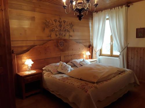 a bedroom with a bed and a chandelier and a window at Le Bellevue in Giron