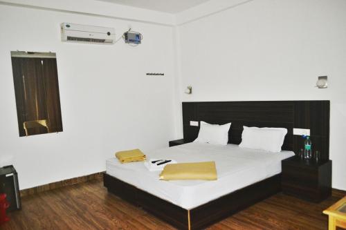 a bedroom with a bed with white sheets and yellow pillows at Crossbill Beach Resort in Havelock Island