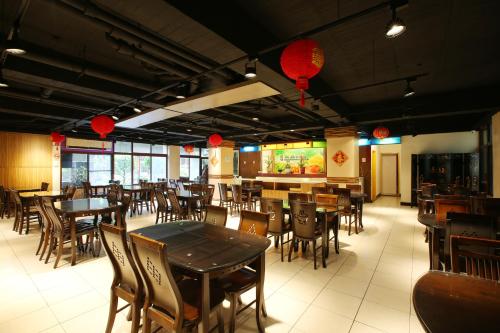 Un comedor con mesas y sillas y faroles rojos. en Chiayi Crown Hotel, en Chiayi