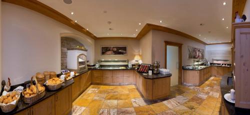 a large kitchen with wooden cabinets and a large island at Alpenresort Fluchthorn in Galtür
