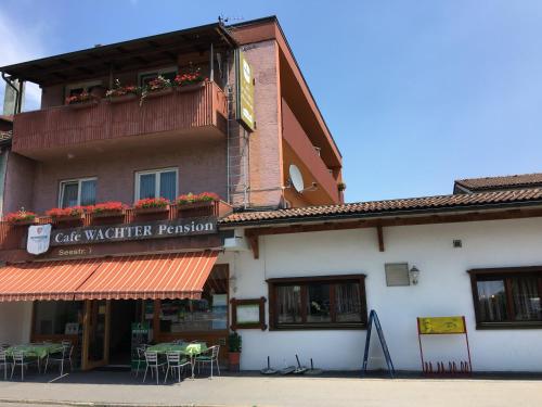 - un bâtiment avec un panneau indiquant un restaurant servant une cafetière dans l'établissement Pension Wachter, à Hörbranz