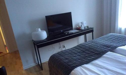 a bedroom with a bed and a television on a table at Villa Ingrid in Borgholm