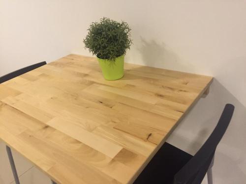 a wooden table with a potted plant on top of it at SHAHALAM ALLBESS@TREFOIL in Setia Alam