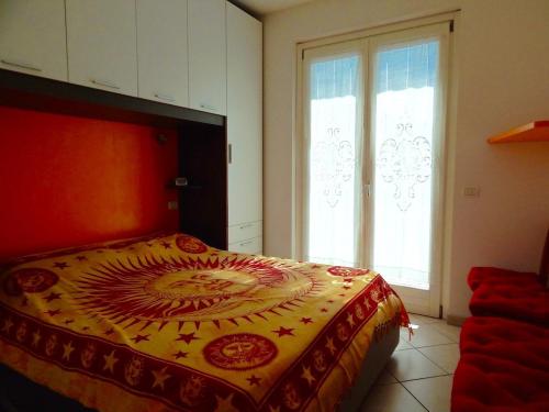 a bedroom with a bed with a red and yellow blanket at N148 - Numana, nuovo trilocale con terrazzo a 350 metri dal mare in Numana