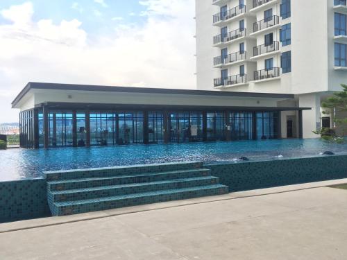 a building with a swimming pool next to a building at SHAHALAM ALLBESS@TREFOIL in Setia Alam