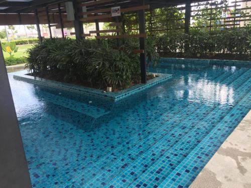 a swimming pool with blue tiles in a building at SHAHALAM ALLBESS@TREFOIL in Setia Alam
