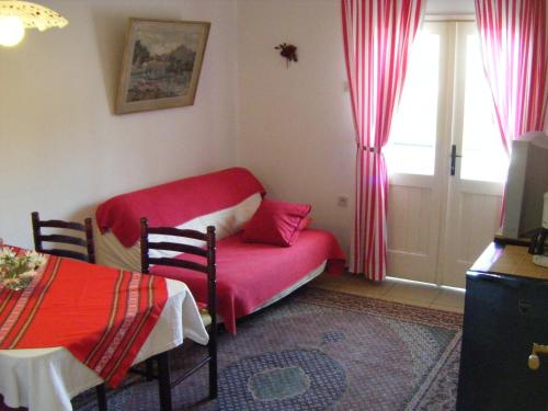 a room with a red bed and a window at Apartments Adria Blue in Jelsa