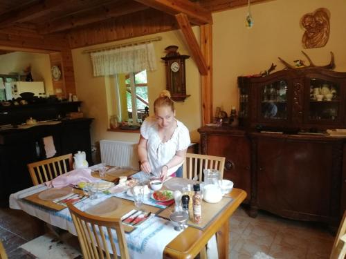 a woman sitting at a table with a baby at Agrojelonki Agroturystyka in Gietrzwałd