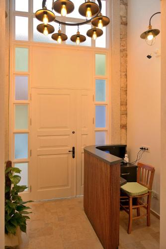 a room with a desk and a door and a chandelier at Brothers Cesme Hotel in Cesme