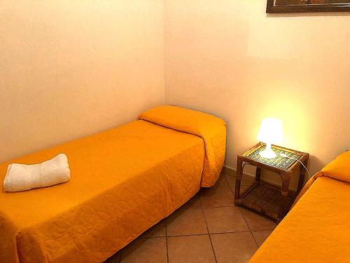アグローポリにあるCasa Vacanze "A Due Passi Dalla Stazione"のベッド2台、テーブル(ランプ付)が備わる客室です。