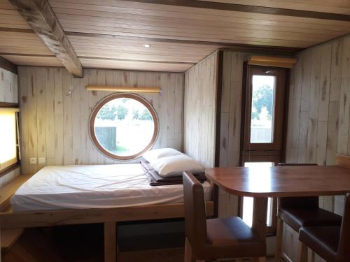 Cette petite chambre comprend un lit et une table. dans l'établissement Les Woodies, à Xertigny
