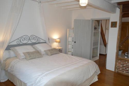 a bedroom with a large white bed in a room at gîte du Clos Sébastien in Beautheil