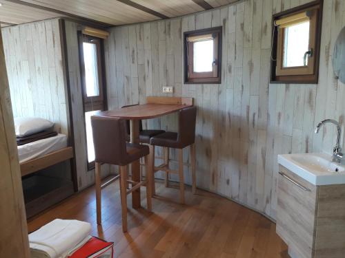 a kitchen with a table and two chairs in a tiny house at Les Woodies in Xertigny