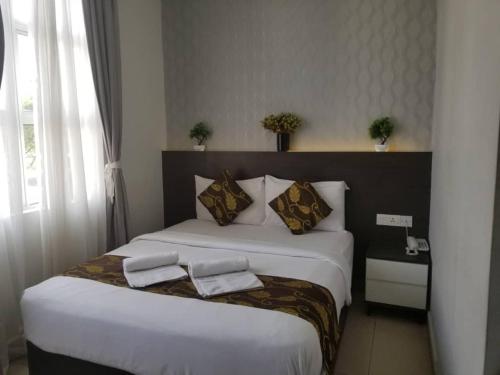 a hotel room with two beds with towels on them at D'Metro Hotel in Shah Alam