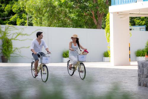 a man and woman riding bikes down a street at Costa Village Bangsaray in Bang Sare