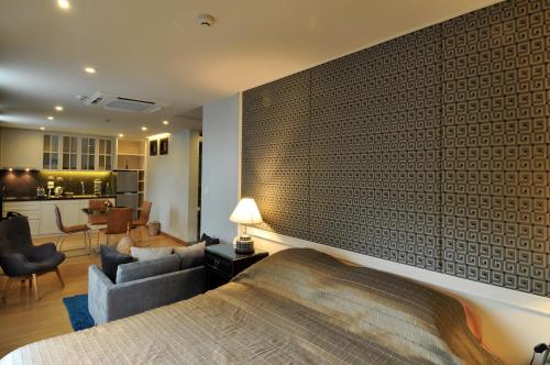 a bedroom with a large brick wall with a bed at Chakrabongse Residences in Bangkok