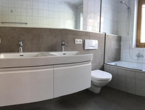 a white bathroom with a sink and a toilet at Unterbachblick in Neukirchen am Großvenediger