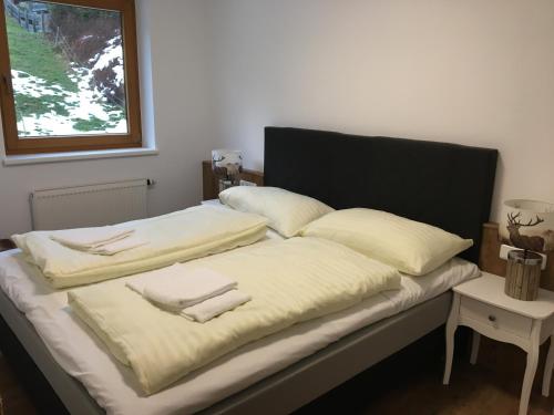 un letto con due cuscini accanto a una finestra di Unterbachblick a Neukirchen am Grossvenediger