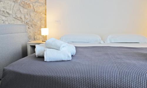 a bedroom with a bed with blue towels on it at Archinuè in Siracusa