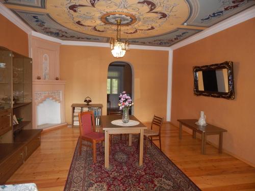 a living room with a table and chairs and a ceiling at Savanna House Jvari in Jvari