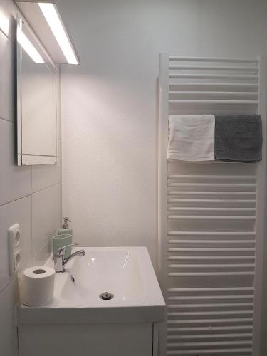 a white bathroom with a sink and a shower at Jutta Deluxe Appartement in Bad Reichenhall